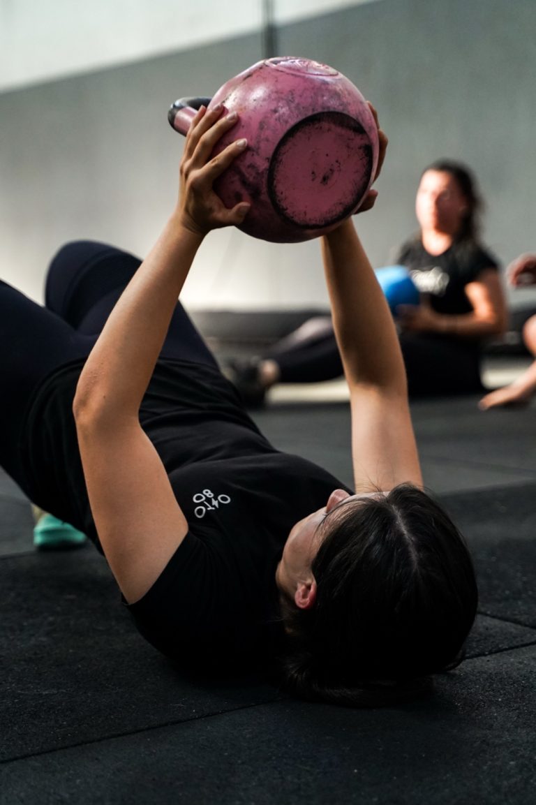 Exercício terapêutico no chão com kettlebell na Oito-80.
