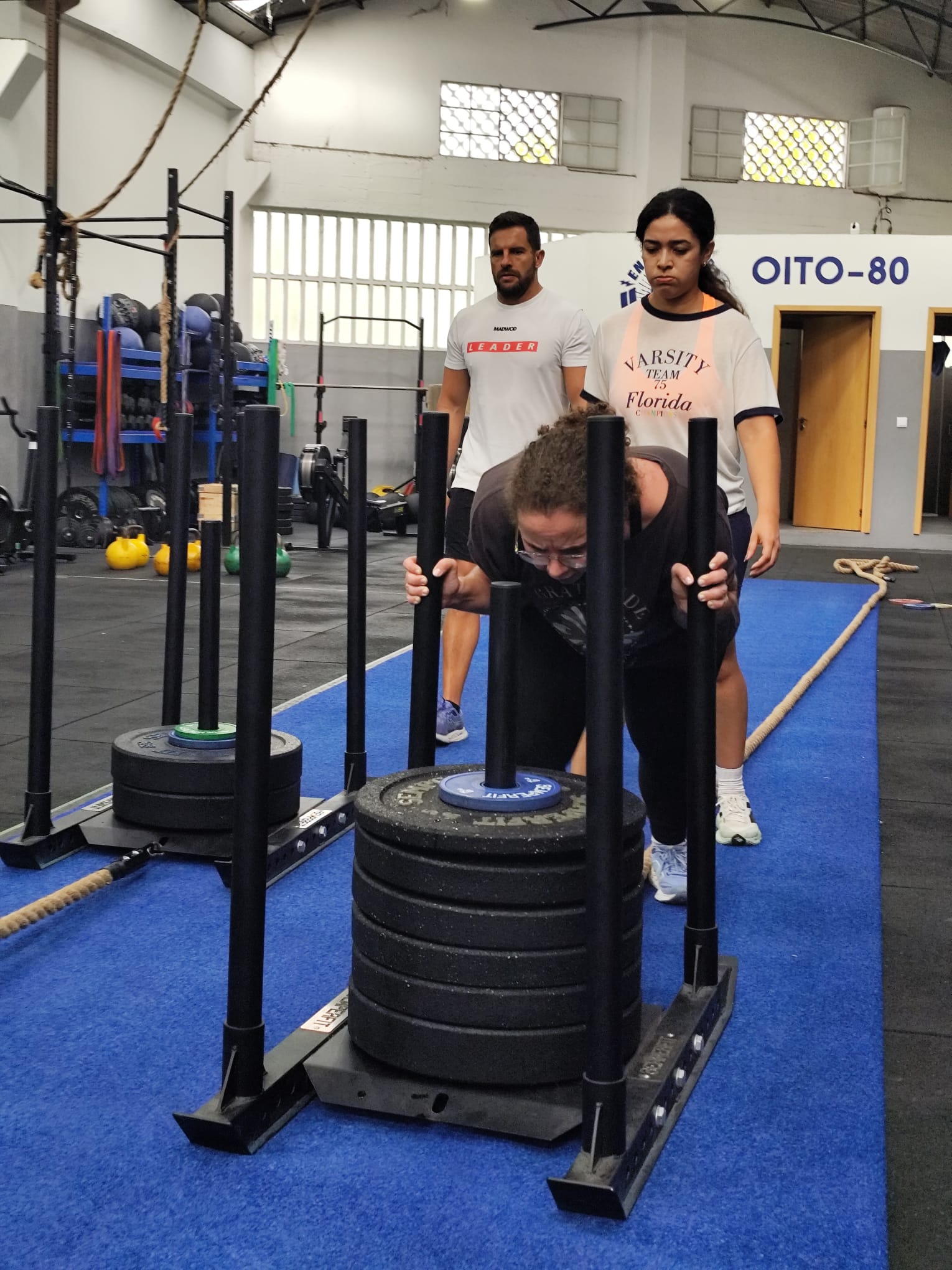 Atleta empurra o sled durante o Hybrid Challenge OITO-80.